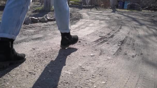 Chica en pantalones vaqueros camina a través del barro en Slow Mo — Vídeos de Stock