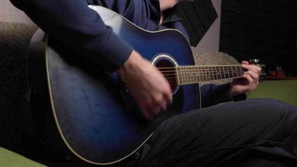 Homem joga uma picareta em uma guitarra moderna no escuro — Vídeo de Stock
