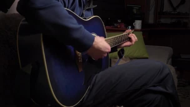 De mens speelt een plectrum op een moderne gitaar in het donker — Stockvideo