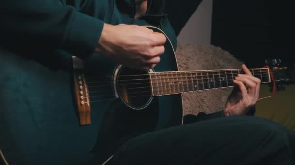 Muž hraje pick na moderní kytaru ve tmě — Stock video