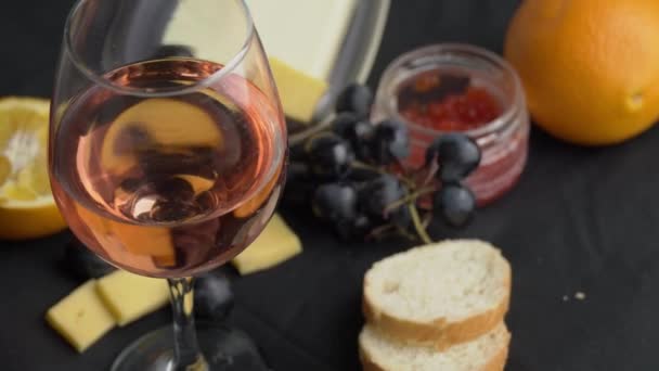 Una copa de vino Ros remolinos con aperitivos — Vídeos de Stock