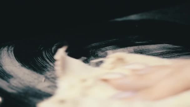 Limpeza de poeira com uma bela mão feminina de uma superfície preta. — Vídeo de Stock