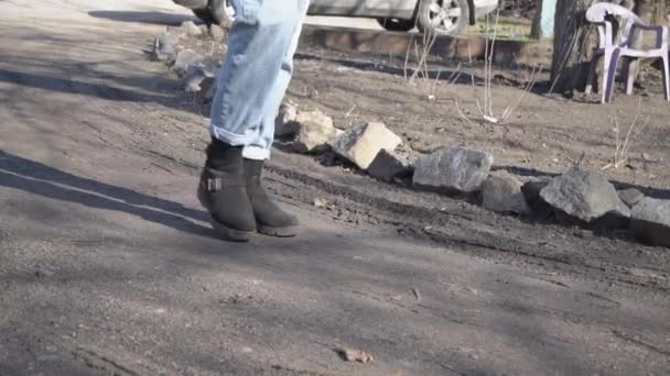 穿牛仔裤的女孩在慢动作的泥巴中穿行 — 图库视频影像