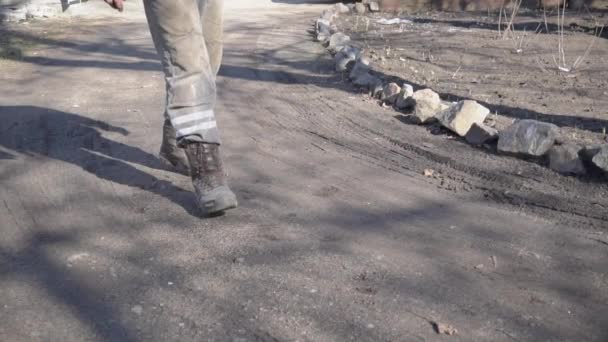 L'homme en uniforme de travail et les bérets à travers la boue en Mo lent — Video