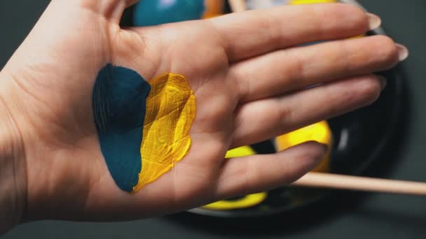 Painted Female Hand in Yellow-Blue Color on the Background of Easter Eggs — Stock Video