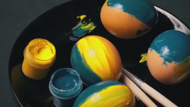 Os ovos de Páscoa amarelo-azuis pintados estão girando — Vídeo de Stock
