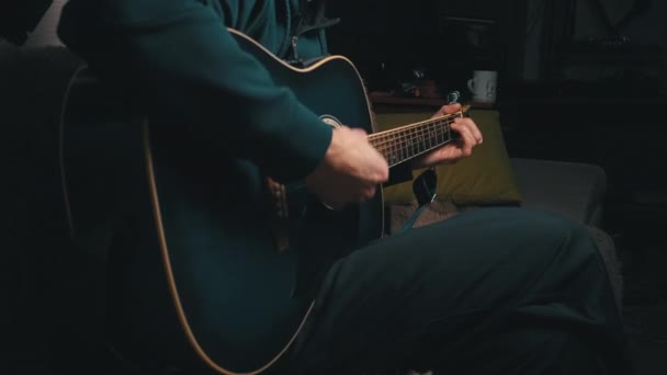 Człowiek gra pick on nowoczesnej gitary w ciemności — Wideo stockowe