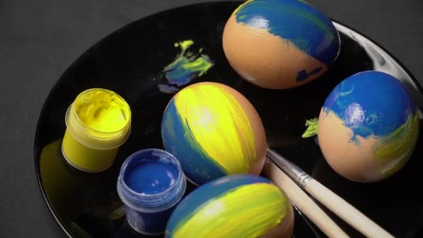 Розфарбовані жовто-блакитні великодні яйця обертаються — стокове відео