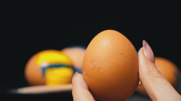 Niña pinta huevos de Pascua en color amarillo-azul — Vídeos de Stock