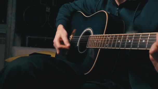 Man spelar en hacka på en modern gitarr i den mörka långsamma Mo — Stockvideo
