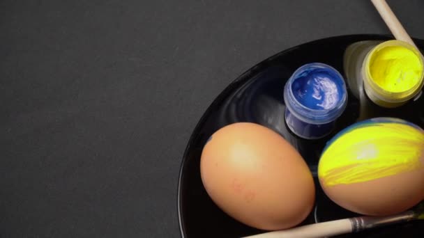 Malované žlutomodré velikonoční vajíčka se točí — Stock video