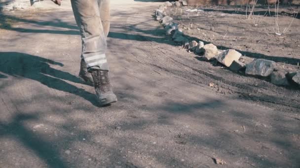 Man in een werkuniform en baretten door de modder in slow mo — Stockvideo