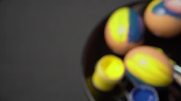 Menina pinta ovos de Páscoa na cor amarelo-azul — Vídeo de Stock