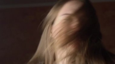 Güzel, genç bir kadın Saçlarını sağa sola sallıyor.