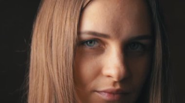 Güzel bir genç kadının yüzü Kameraya bakıp gülümsüyor