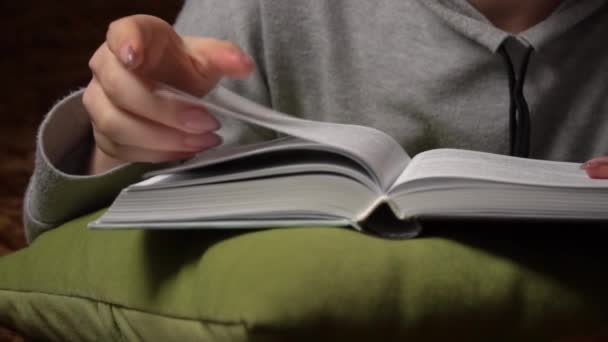 Όμορφη κοπέλα διαβάζει ένα βιβλίο άνετα, ενώ βρίσκεται στο κρεβάτι — Αρχείο Βίντεο