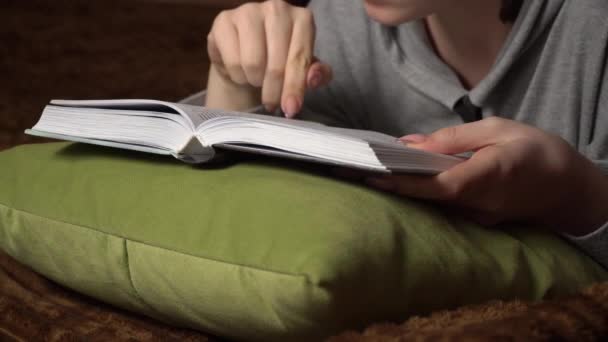 Mooi meisje leest een boek comfortabel terwijl liggend in bed — Stockvideo