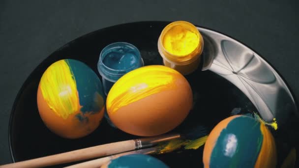 Pintado amarillo-azul huevos de Pascua están girando — Vídeos de Stock