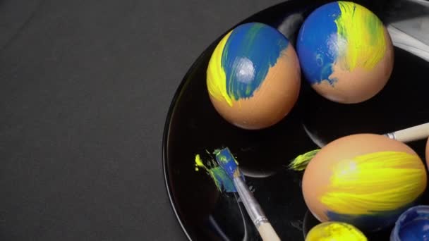 Os ovos de Páscoa amarelo-azuis pintados estão girando — Vídeo de Stock