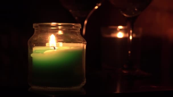 Aroma gyertyák égnek esténként egy asztalon két pohár borral — Stock videók