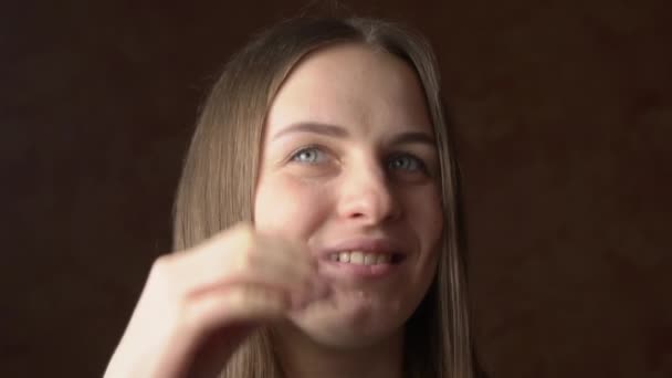 Rostro de una hermosa joven enderezando su cabello detrás de su oreja — Vídeo de stock