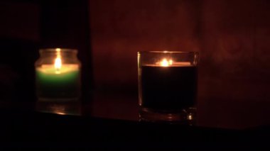Aroma Mumları, iki kadeh şarapla bir masada yanar.
