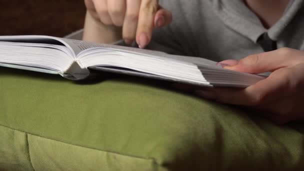 Gyönyörű lány olvas egy könyvet kényelmesen, miközben fekszik az ágyban — Stock videók
