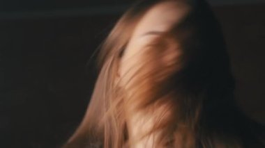 Güzel, genç bir kadın Saçlarını sağa sola sallıyor.