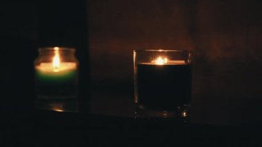 Aroma Mumları, iki kadeh şarapla bir masada yanar.