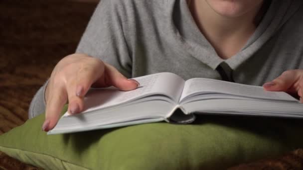 Όμορφη κοπέλα διαβάζει ένα βιβλίο άνετα, ενώ βρίσκεται στο κρεβάτι — Αρχείο Βίντεο