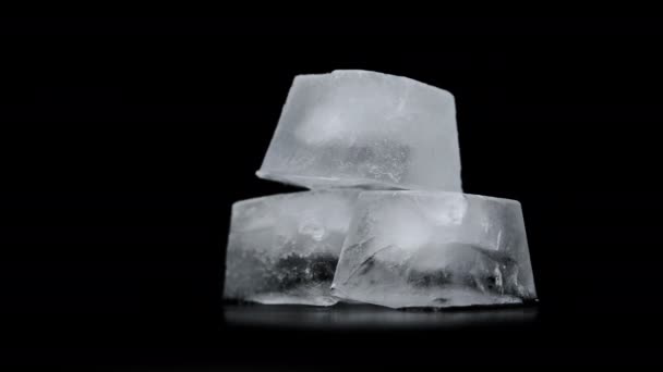 Cubos de hielo cuadrados giran sobre un fondo negro — Vídeos de Stock