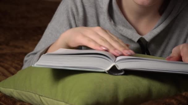 Mooi meisje leest een boek comfortabel terwijl liggend in bed — Stockvideo