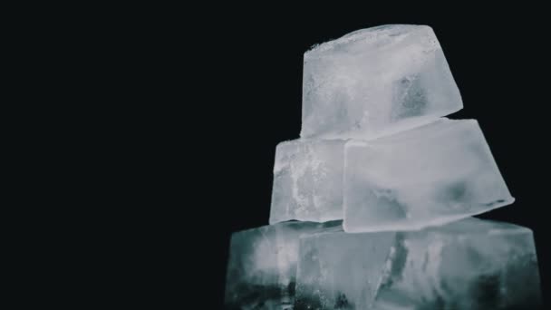 I cubetti di ghiaccio quadrati girano su uno sfondo nero — Video Stock