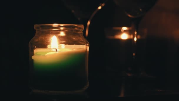 Bougies d'arôme brûlent le soir sur une table avec deux verres de vin — Video