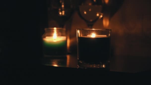 Velas de Aroma queimam à noite em uma mesa com dois copos de vinho — Vídeo de Stock