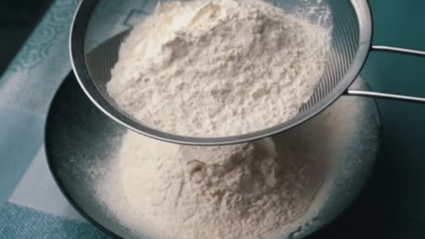 Młoda dziewczyna przesiewa mąkę przez sito do dania do pieczenia, widok z bliska — Wideo stockowe