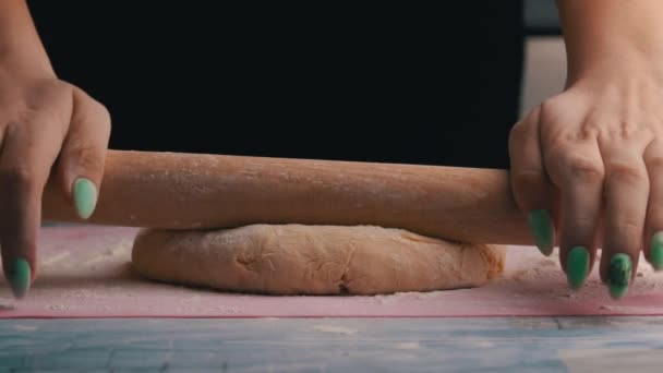 Молодая девушка выкатывает сырое тесто с булавкой в Медленном Мо — стоковое видео