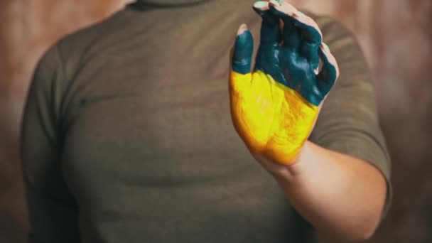 La main d'une fille avec le drapeau de l'Ukraine demande d'arrêter la guerre — Video