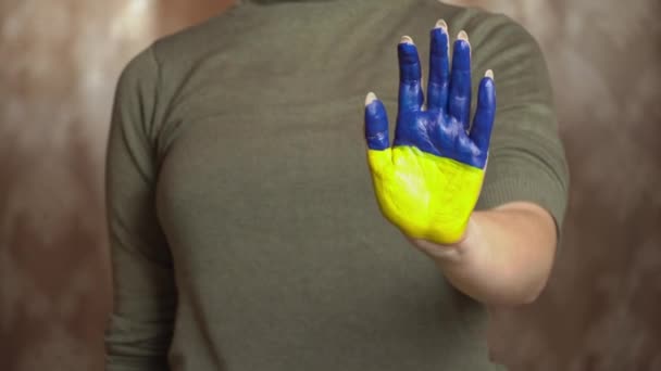 Mão de uma menina com a bandeira da Ucrânia pede para parar a guerra — Vídeo de Stock