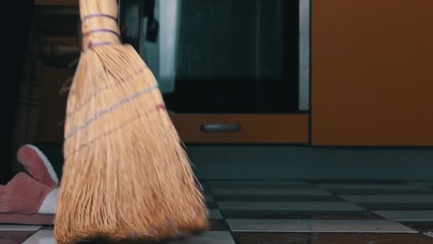 Rapariga varre o chão na cozinha com um Vassoura Ordinária em Slow Mo — Vídeo de Stock