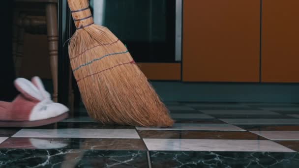 Mladá dívka zametá podlahu v kuchyni s obyčejným koštětem v pomalé Mo — Stock video