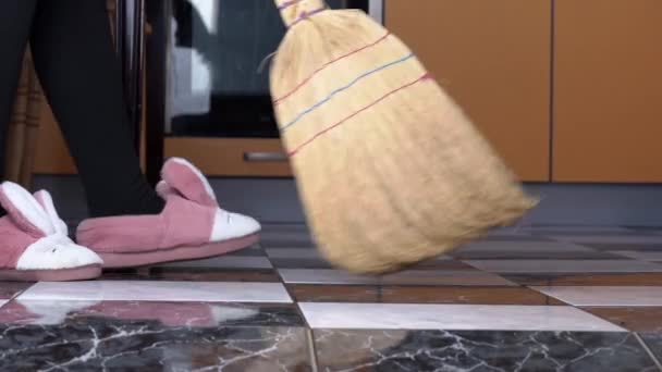 Молодая девушка подметает пол на кухне с обычной метлой в Медленном Мо — стоковое видео