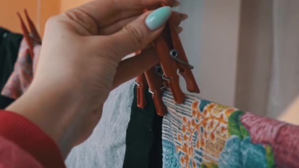 La ropa se seca en una cuerda con pinzas rojas bajo los rayos del sol — Vídeo de stock