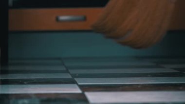 Genç kız mutfaktaki yerleri süpürüyor sıradan bir süpürgeyle
