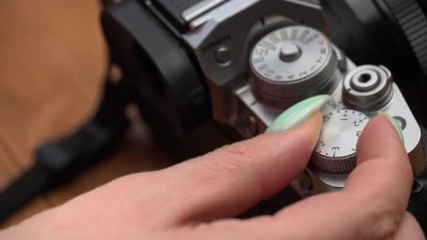 Las manos de las mujeres tuercen la rueda de abertura en un primer plano de la cámara Vintage — Vídeo de stock