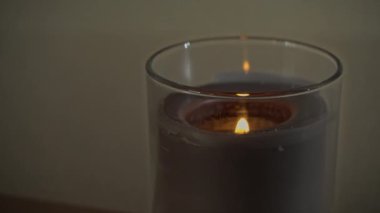 Atmosferik olarak, bir mum akşam karanlığında kendi gölgesini yayarak yanar.