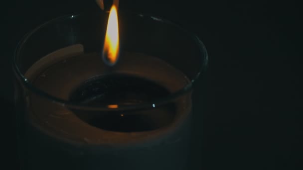 Атмосферно, свеча - это свеча со спичкой от руки девушки — стоковое видео