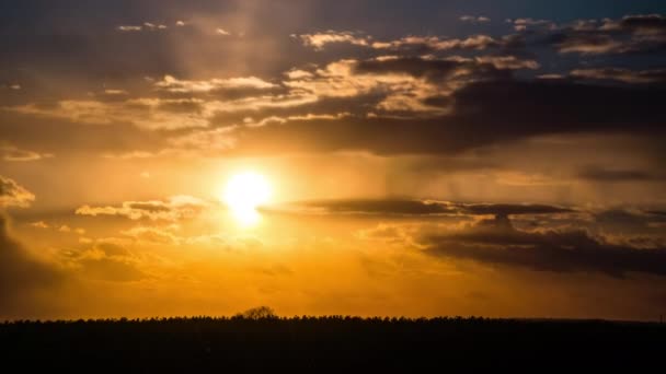 Timelapse de una puesta de sol naranja brillante con nubes flotantes en el cielo — Vídeos de Stock