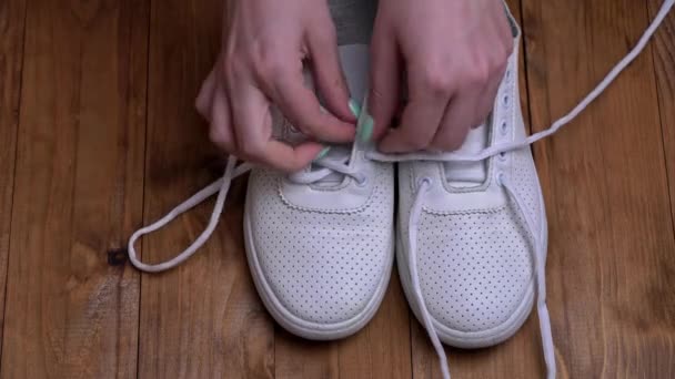 Ragazze mani allacciano scarpe da ginnastica bianche in un colpo veloce — Video Stock