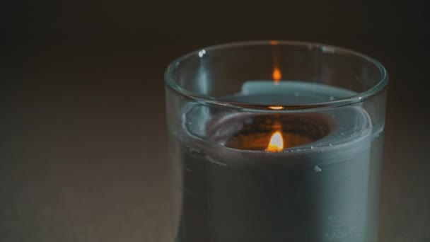 Atmosféricamente, una vela arde, emitiendo su propia sombra en la noche — Vídeos de Stock